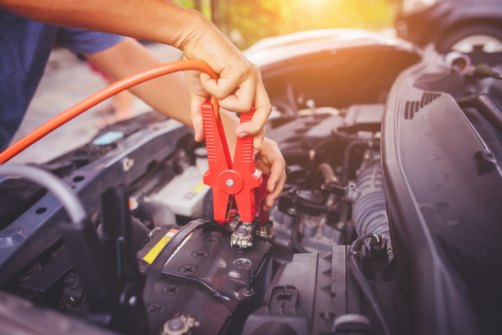 Starthulp geven met startkabels op een lege auto-accu onder de motorkap